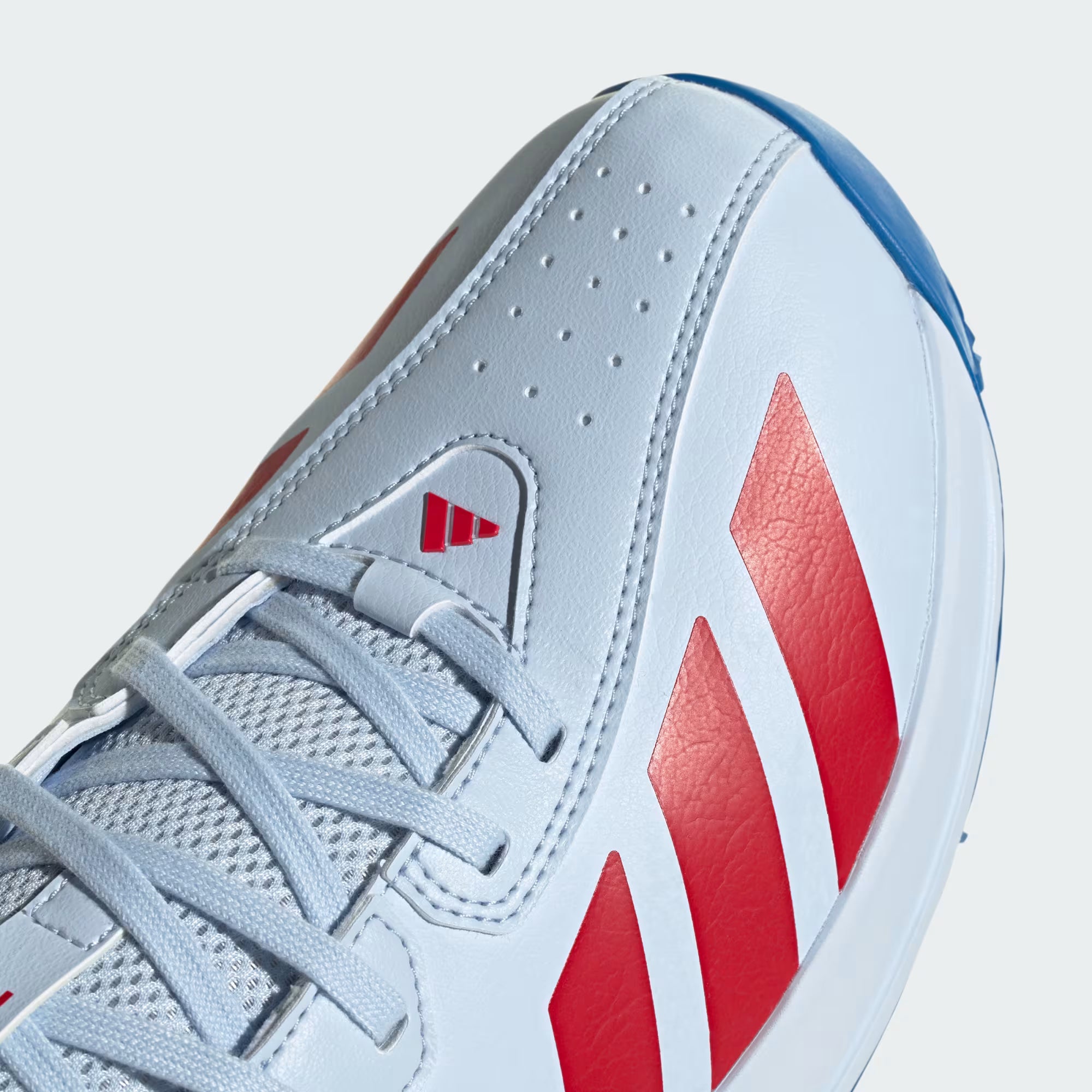 Close-up of a light blue athletic shoe with red accents on a white background
