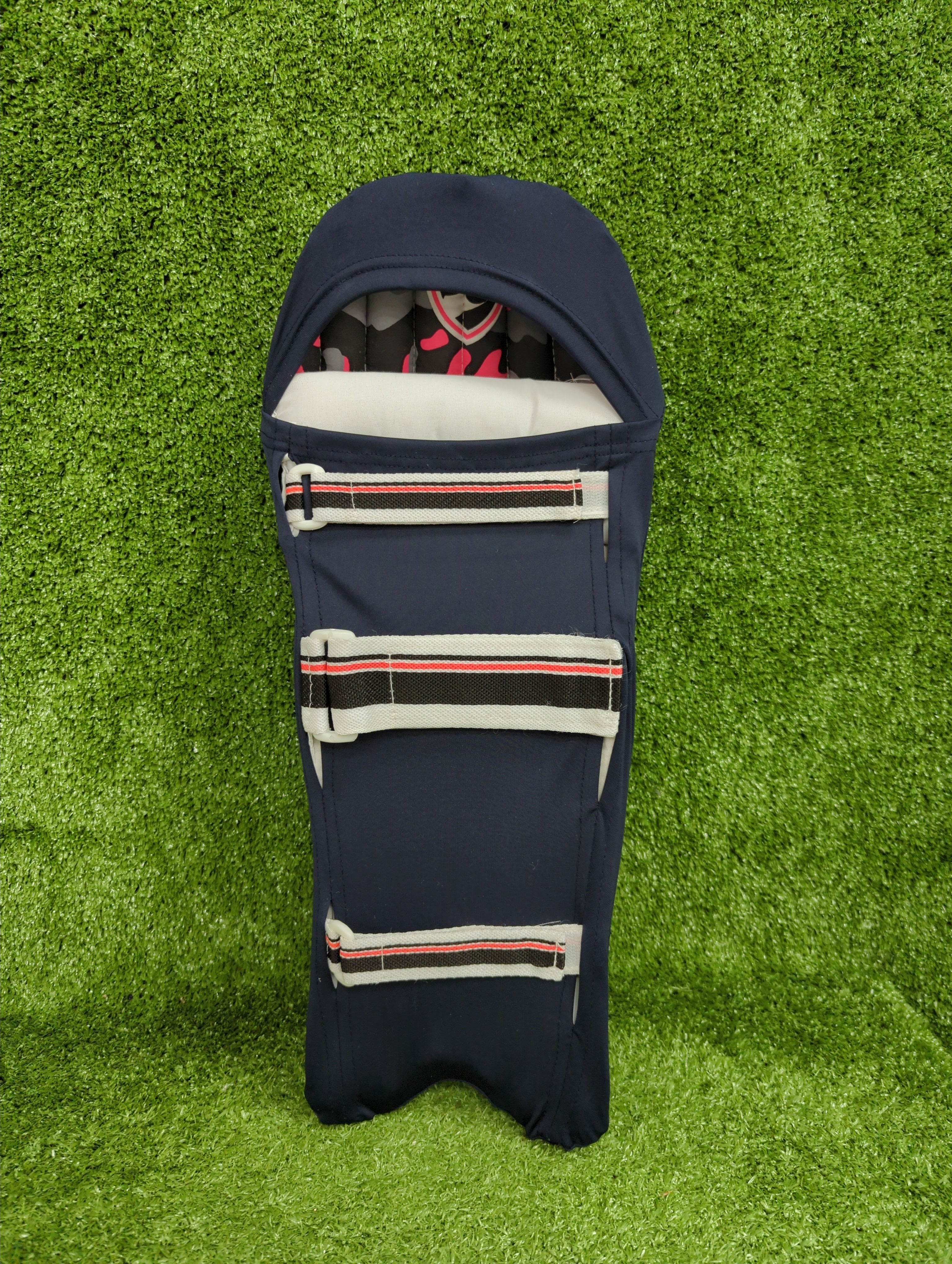 Back view showing how the Raydn navy batting clads strap and secure onto a junior cricket pad.